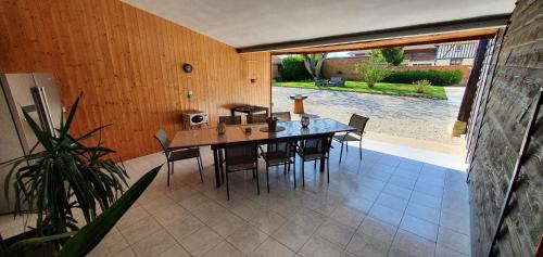 une salle à manger avec une table et des chaises sur un patio dans l'établissement La pinsonnière, à Heiltz-le-Hutier