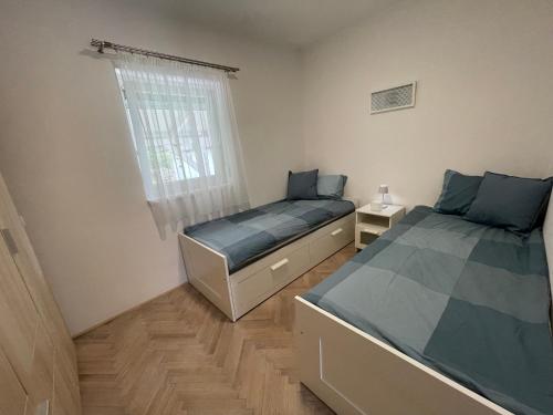 1 dormitorio con 2 camas y ventana en HelloMária, en Balatonmáriafürdő