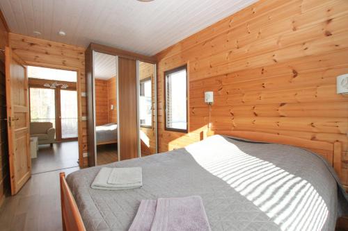 a bedroom with a bed in a wooden wall at Saimaan Aarre in Tiuruniemi