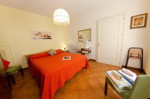 een slaapkamer met een bed met een oranje deken bij La Piccola Margherita in Capannori