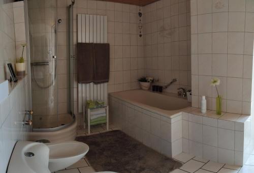 La salle de bains est pourvue d'une baignoire, de toilettes et d'un lavabo. dans l'établissement Ferienhaus Treis, à Neef