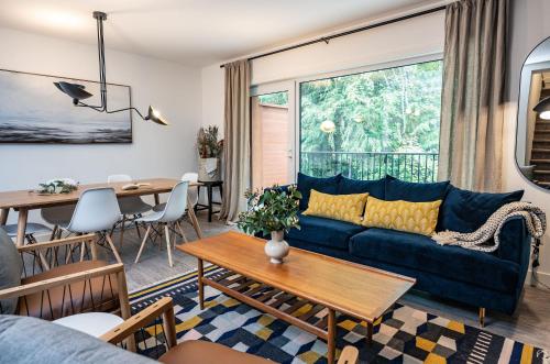 a living room with a blue couch and a table at Revelation Retreat by Revelstoke Vacations in Revelstoke
