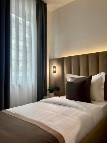 a bedroom with a large bed with a window at Bayer's City Hotel in Munich