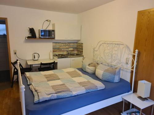 Cet appartement comprend une chambre avec un lit et une table ainsi qu'une cuisine. dans l'établissement Ferienwohnung Kramer, à Kippenheim