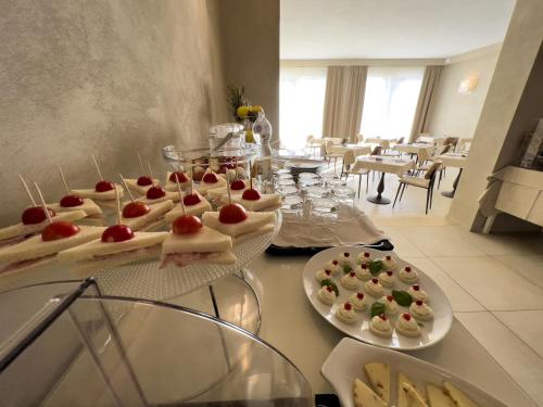 a buffet with appetizers on plates on a table at Hotel Cecina Beach in Marina di Cecina