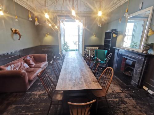 una mesa larga en una habitación con sillas y sofá en The Townhouse, en Falmouth