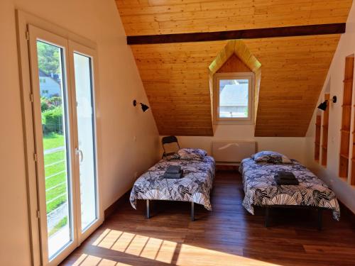 two beds in a room with two windows at Grande villa avec jardin privatif - Bagnères de Luchon in Juzet-de-Luchon