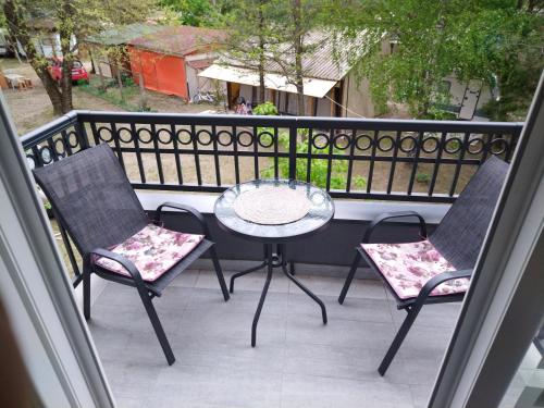 a patio with two chairs and a table on a balcony at Apartman "N" Srebrno jezero in Ostrovo