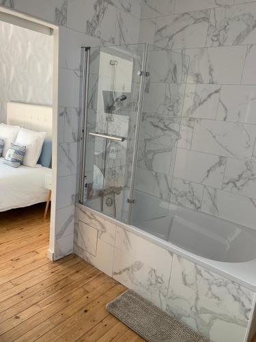 een badkamer met een douche en een glazen deur bij VILLA CATHY Chambres d hôtes in Dives-sur-Mer