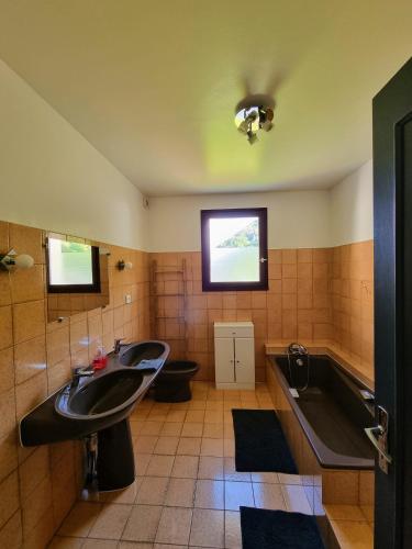 une salle de bain avec deux lavabos et une baignoire dans l'établissement Grande villa avec jardin privatif - Bagnères de Luchon, à Juzet-de-Luchon
