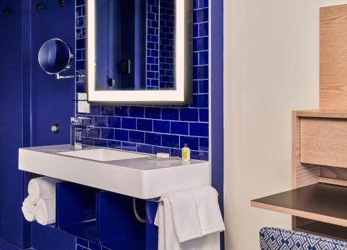 baño con lavabo blanco y azulejos azules en Radio Hotel en Nueva York
