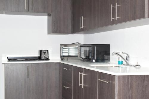 a kitchen with wooden cabinets and a sink and a microwave at Days Inn by Wyndham Kingston in Kingston