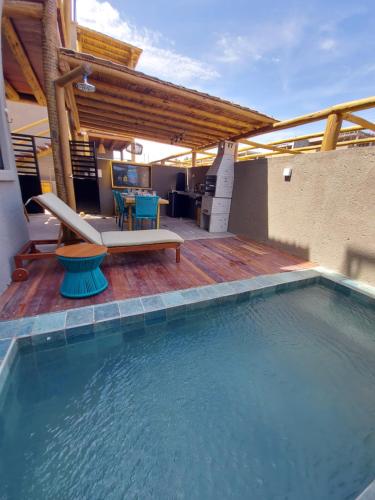 a swimming pool with a table and a bench on a patio at Casa Riacho in São Miguel dos Milagres