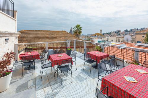 a patio with red tables and chairs on a balcony at Michel House in Nazareth