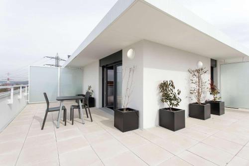 a balcony with a table and chairs and potted plants at Tulip Inn Massy Palaiseau - Residence in Palaiseau