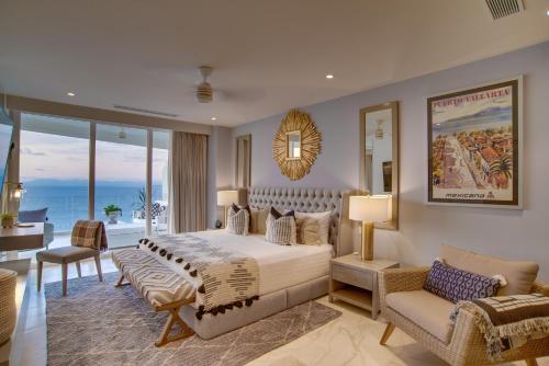 a bedroom with a large bed and a living room at Maxwell Residences at Indah in Puerto Vallarta