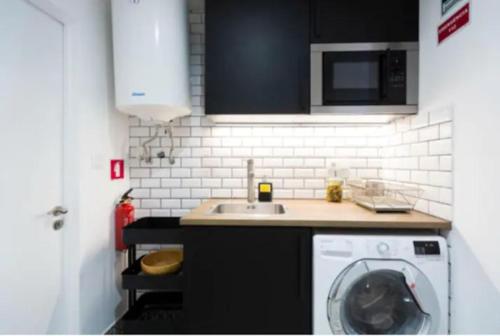 eine Küche mit einer Waschmaschine und einem Waschbecken in der Unterkunft Olá Lisbon- Castelo V in Lissabon