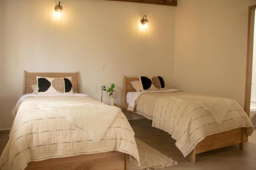 two beds in a room with white walls at Terramia Estate in Minca