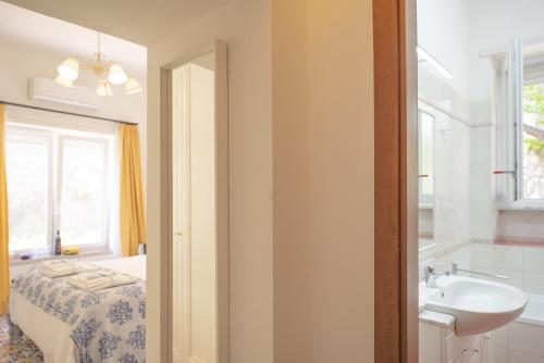 a bathroom with a sink and a bed and a window at Villa Dorothee in Capri