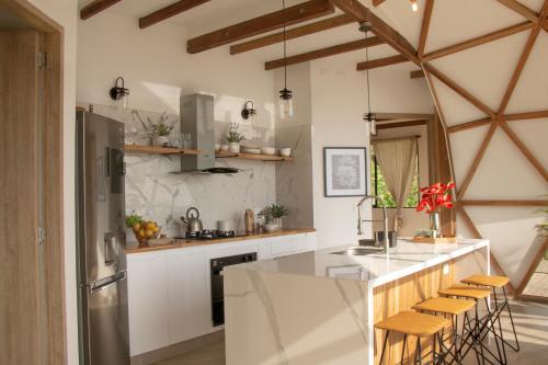 a kitchen with white cabinets and a counter with stools at Terramia Estate in Minca