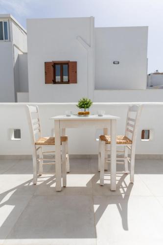 a white table and chairs in a white room at Krina Mare Boutique Hotel in Naxos Chora