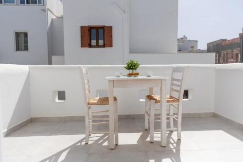 a white table and chairs on a balcony at Krina Mare Boutique Hotel in Naxos Chora