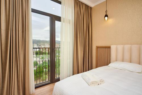Un dormitorio con una cama y una ventana grande. en Apartment by the river, en Tiflis