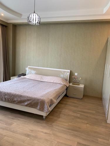 a bedroom with a bed and a chandelier at APARTMENT IN THE NEW CITY in Tbilisi City