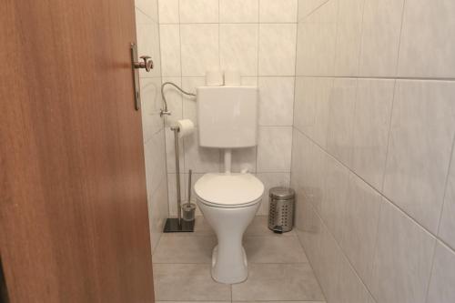 a bathroom with a white toilet in a tiled room at Gasthof Pension Pichlernwirt in Himmelberg