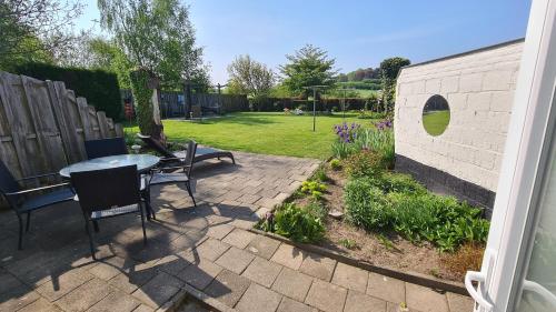 a patio with a table and chairs and a garden at Roos Guesthouse Holiday Appartements in Valkenburg