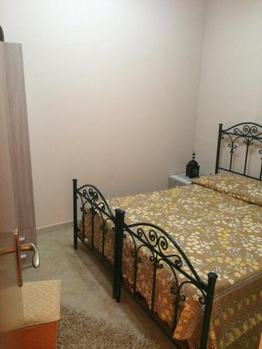 a bedroom with a black bed with a floral bedspread at Apartment A&M in Marsala
