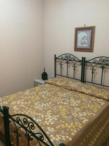 a bedroom with a bed with a floral bedspread at Apartment A&M in Marsala