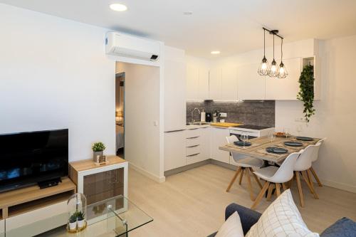 a kitchen and living room with a table and chairs at Preciosos Apartamentos Reformados en Son Bou in Son Bou