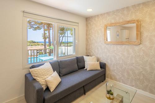 a living room with a couch and a window at Preciosos Apartamentos Reformados en Son Bou in Son Bou