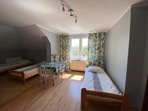 a room with two beds and a table and a window at Zacisze u Rysia in Brochów