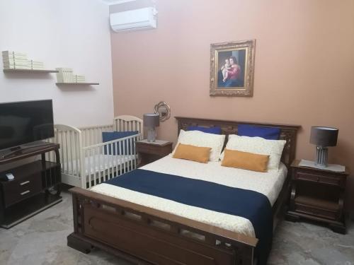 1 dormitorio con 1 cama y TV de pantalla plana en Le stanze di Anna, en Capaci