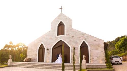 a church with a bride standing in front of it at Hotel Fazenda Lago São Francisco in São João