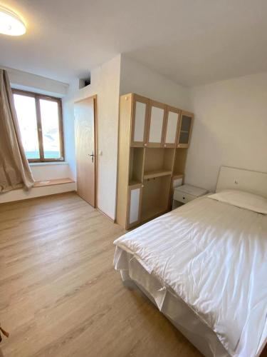 1 dormitorio con cama blanca y ventana en Panda Royal Klettgau en Klettgau