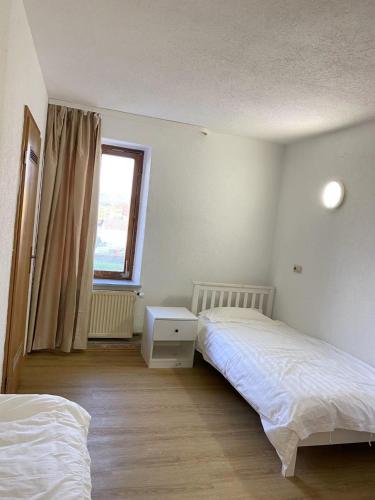 a bedroom with two beds and a window at Panda Royal Klettgau in Klettgau