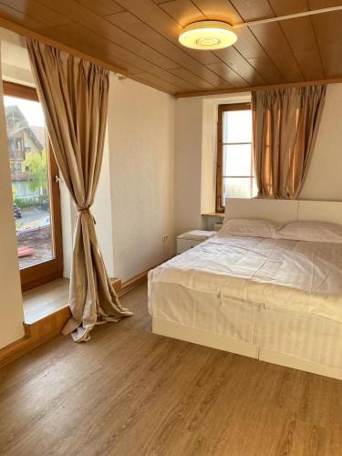 a bedroom with a bed and a large window at Panda Royal Klettgau in Klettgau