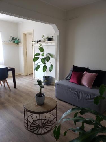 ein Wohnzimmer mit einem Sofa und einem Tisch mit Pflanzen in der Unterkunft Piso Macario ¡muy céntrico y bien comunicado! in Mexiko-Stadt