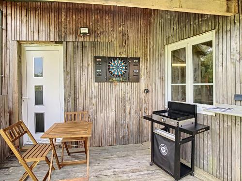 a patio with a table and a dart board on a wall at Le Chat Qui Veille in Bayeux