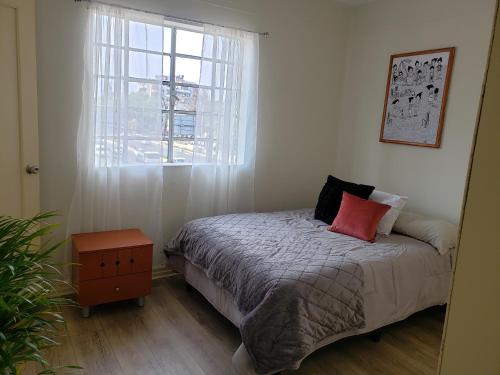 1 dormitorio con cama y ventana en Piso Macario ¡muy céntrico y bien comunicado!, en Ciudad de México