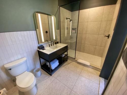 een badkamer met een toilet, een wastafel en een douche bij Kinn Guesthouse Downtown in Milwaukee
