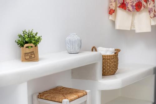 a white shelf with a stool and a basket at Krina Mare Boutique Hotel in Naxos Chora
