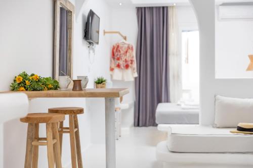 a living room with a table and two stools at Krina Mare Boutique Hotel in Naxos Chora
