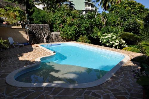 una pequeña piscina en un patio con patio en Appartement Villa Taina piscine, en Punaauia