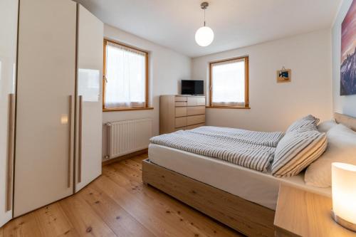 - une chambre avec un lit et un réfrigérateur dans l'établissement CASA BEBA - trilocale accogliente, Dolomiti Affitti, à Cavalese