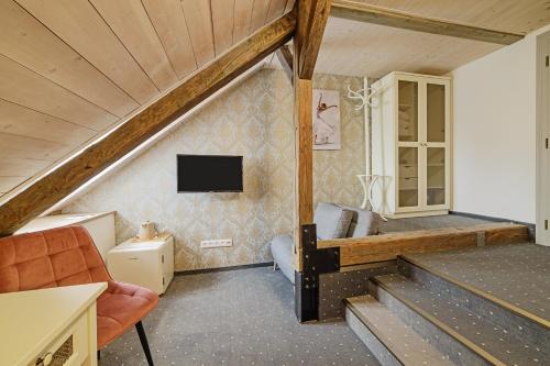バンスカー・シュチャヴニツァにあるAuraのベッド1台と壁掛けテレビが備わる客室です。