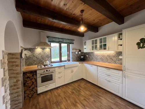 a kitchen with white cabinets and wooden floors at Chalupa U Dvořáků in Lomnice nad Lužnicí